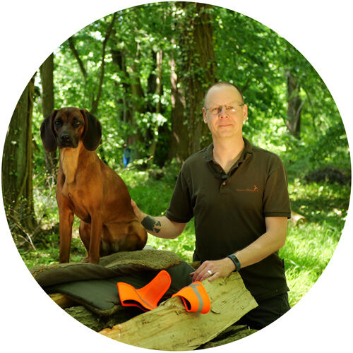 Portrait von Hundeführer Christian nebst bayerischem Gebirgsschweißhund Blanka im Wald