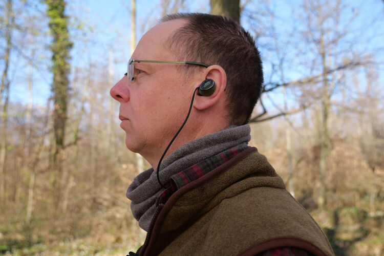 Isotunes Caliber im Ohr mit Sicherungsband, das um den Hals läuft